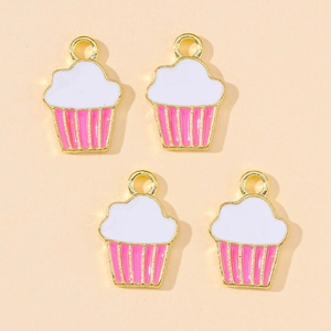 Macro view of four enamel cupcake charms with pink stripes and gold finish for DIY crafts