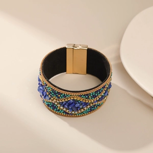 Detalle de pulsera bohemia con piedras azules y cierre magnético de metal dorado