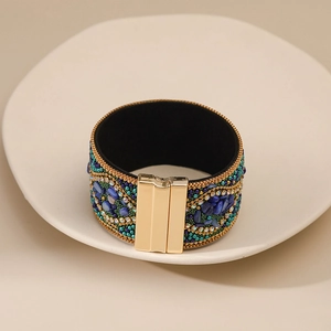 Detalle de pulsera boho hecha a mano con piedras azules y cierre magnético dorado