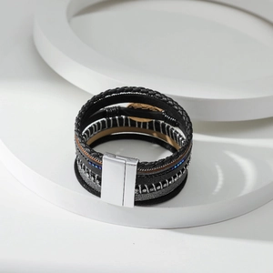 Detail van meerlagige leren armband met blauwe strass-steentjes en magneetsluiting