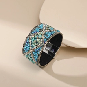 Detalle de pulsera ancha bohemia con piedras turquesas y cierre magnético de plata