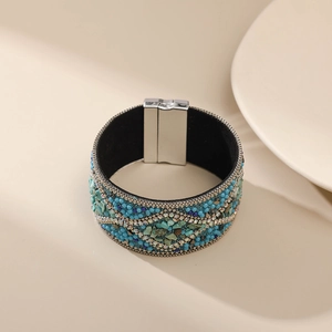 Detalle de una pulsera magnética ancha bohemia con piedras turquesas y pedrería