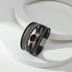Macrodetail van een boheemse meerlagige leren armband met kristallen inleg en magneetsluiting