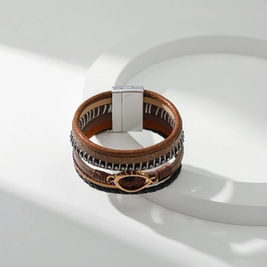 Detail van bohemien meerlaagse leren armband met oogvormige hanger en magnetische sluiting