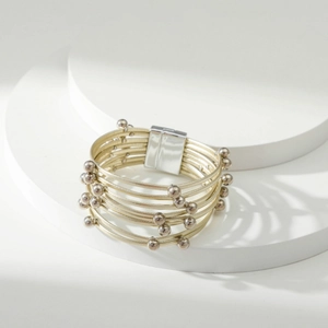 Detailopname van meerlagige champagne-gouden kralenarmband met zilveren magnetische sluiting