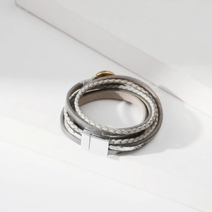 Dettaglio bracciale multistrato in pelle con cinturini glitterati e chiusura magnetica