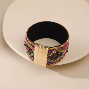 Detalle de una pulsera multicapa bohemia con cuentas de colores y cierre magnético