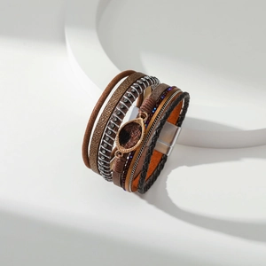 Detail van de gelaagde boho lederen armband met bronzen bedel en een magnetische sluiting