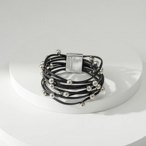 Detail van een bohemian meerlaagse leren armband met zilveren kralen en magneetsluiting