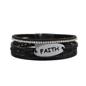 Detailansicht eines mehrlagigen Lederarmbands mit FAITH-Gravurplatte und Magnetverschluss