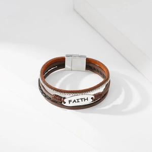 Detail der Faith-Metallplatte auf einem mehrlagigen Lederarmband mit Magnetverschluss