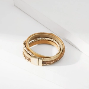 Dettaglio di un bracciale beige multistrato con chiusura magnetica dorata