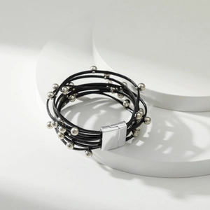 Detail van meerlaagse leren armband met zilveren kralen en metalen magneetsluiting