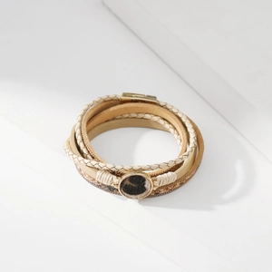 Dettaglio di un bracciale boho a più strati con pelo leopardato e chiusura magnetica dorata