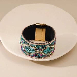 Detalle de pulsera bohemia con cuentas de turquesa y cierre magnético de metal dorado