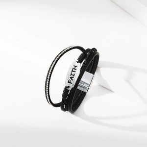 Detail eines mehrlagigen Lederarmbands mit FAITH-Gravurplatte und Magnetverschluss