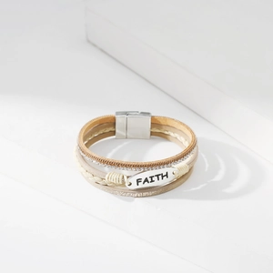 Detail eines mehrlagigen Lederarmbands mit FAITH-Metallplatte und glitzernden Strasssteinen