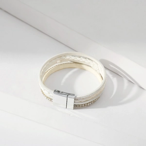 Detail von weißem mehrlagigem Lederarmband mit Glitzersteinen und Magnetverschluss