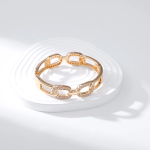 Detailed close-up of a gold hollow-out chain bracelet with micro-pave zircon settings