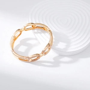 Macro shot of gold oval link bracelet with micro-pave crystals on ripple display stand