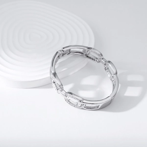 Detailed view of silver oval link bracelet with sparkling pavé set rhinestones on white