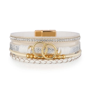 Detail of white leather wrap bracelet with golden infinity rings and magnetic buckle