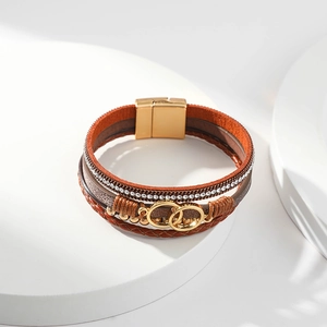 Close-up of bohemian leather bracelet with gold interlocking rings and magnetic clasp
