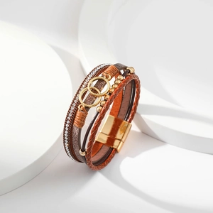 Close-up of layered leather bracelet featuring golden rings and magnetic clasp detail