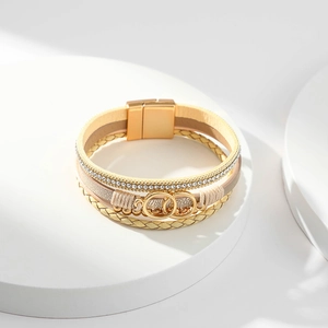 Close-up of layered leather bracelet with rhinestone accents and golden magnetic clasp