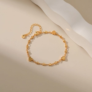 Detail view of 18K gold plated heart charm bracelet with lobster clasp and extender