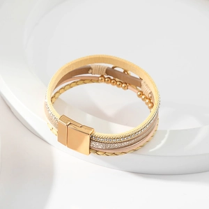 Detail of bohemian multilayer leather bracelet with golden beads and magnetic square clasp