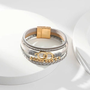 Detail of multi-layer leather bracelet with gold interlocking rings and magnetic clasp