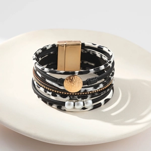 Détail d'un bracelet bohème en cuir multicouche avec motif léopard et fermoir magnétique