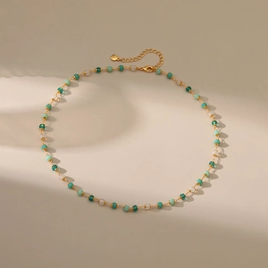 Detail of adjustable gold-plated chain and light green crystal beads on a necklace