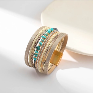 Détail d'un bracelet bohème en cuir avec pierres turquoise et fermoir magnétique doré