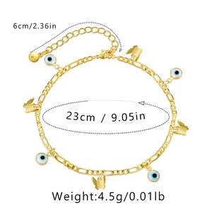 Détail des breloques œil maléfique et papillon dorées 18K sur une chaîne de cheville