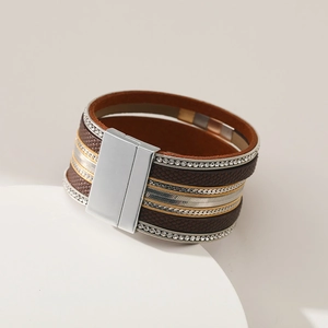 Detail of bohemian multilayer bracelet featuring dark brown leather and silver magnetic clasp