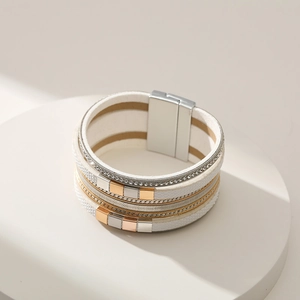 Detail of multi-layer white leather bracelet with rhinestones and magnetic clasp