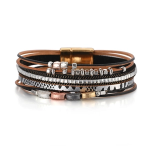 Detail of bohemian leather bracelet featuring leaf charms and crystal layered strands