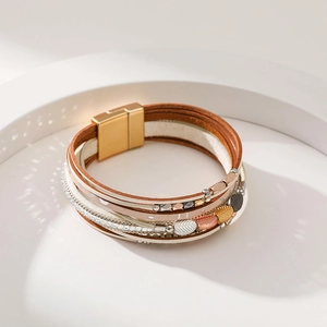 Detail of bohemian multilayer leather bracelet with metal leaf charm and magnetic clasp