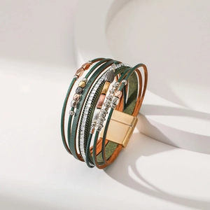 Detail of bohemian multilayer green leather bracelet with leaf charm and magnetic clasp