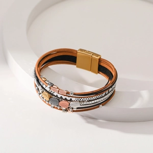 Detail of bohemian multilayer leather bracelet with leaf charms and magnetic clasp