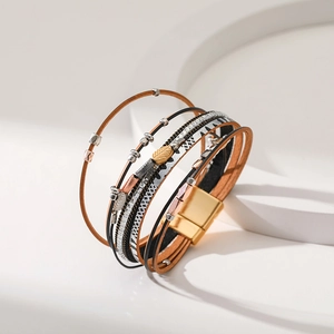 Macro shot of Bohemian multilayer leather bracelet featuring leaf charms and magnetic clasp