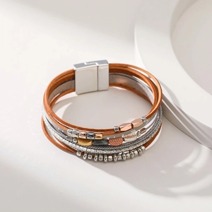 Detail of bohemian multilayer leather bracelet with leaf charms and magnetic clasp