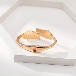 Bracciale aperto in oro design geometrico foglia con texture piuma e piccoli diamanti