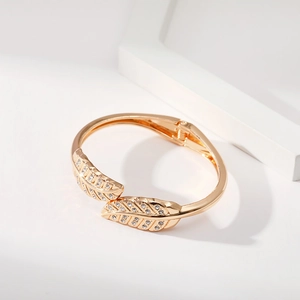 Dettaglio macro del bracciale a foglia dorata con diamanti e cerniera a molla