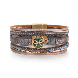Dettaglio del bracciale bohémien multistrato con ciondolo a fiocco e strass luminosi