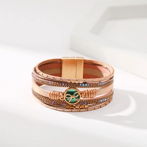 Dettaglio di bracciale boho multistrato con catene di cristallo e chiusura magnetica