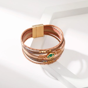 Dettaglio del bracciale bohémien multistrato in pelle con chiusura magnetica e gemma