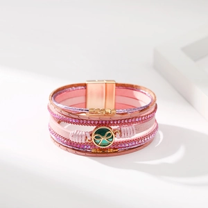 Dettaglio bracciale multistrato in pelle rosa con inserti di strass e chiusura magnetica
